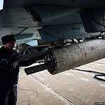 Загрузка неуправляемых ракет во время подготовки самолета Су-25СМ к вылету